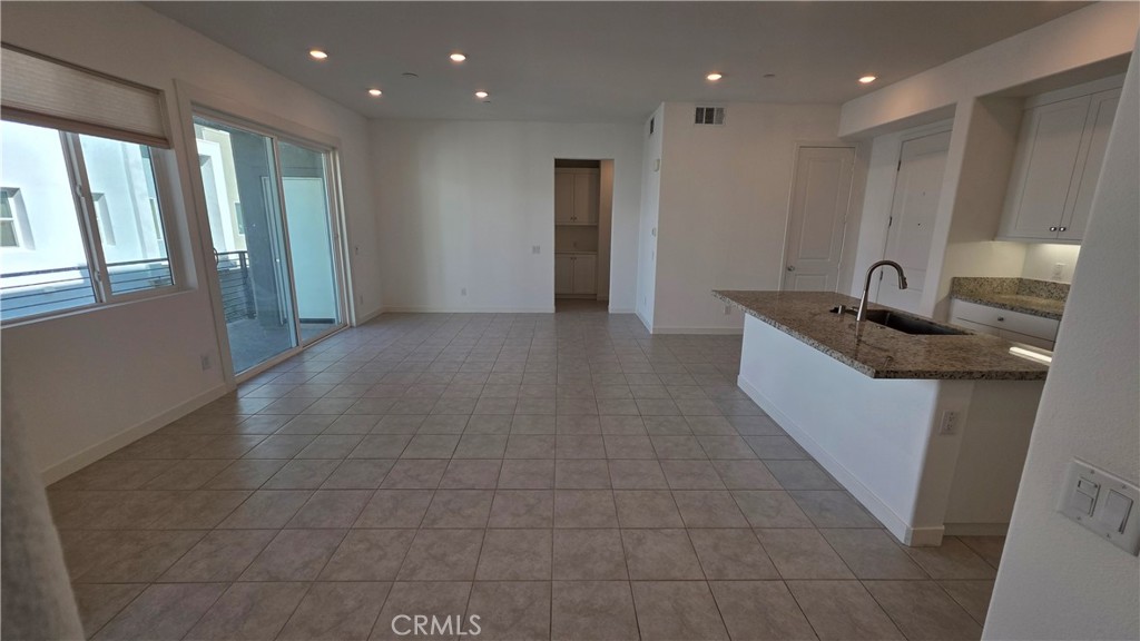 26955 West Prospector Road, Unit 201 Valencia, CA 91381 - Photo 7 of 30 a kitchen with granite countertop a sink and a refrigerator