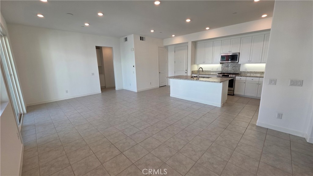 26955 West Prospector Road, Unit 201 Valencia, CA 91381 - Photo 8 of 30 a large kitchen with stainless steel appliances a large counter top and a stove top oven