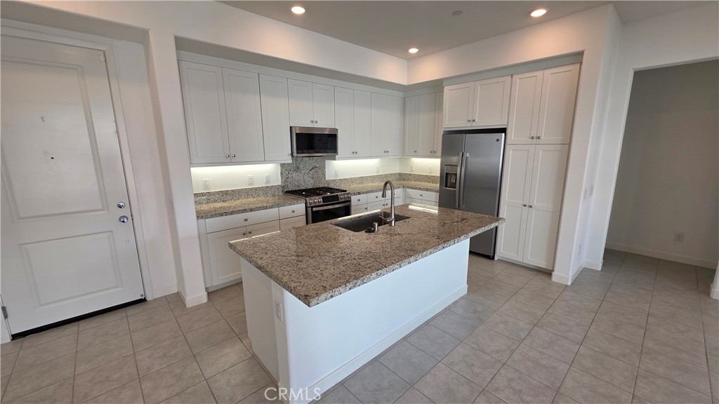26955 West Prospector Road, Unit 201 Valencia, CA 91381 - Photo 9 of 30 a kitchen with stainless steel appliances granite countertop a sink stove and refrigerator