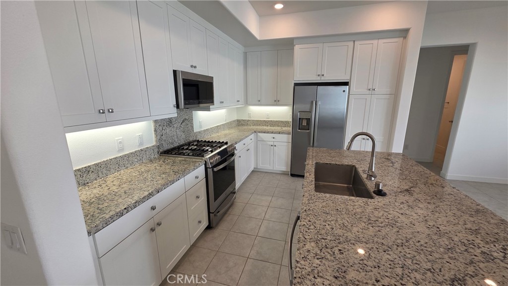 26955 West Prospector Road, Unit 201 Valencia, CA 91381 - Photo 10 of 30 a kitchen with stainless steel appliances granite countertop a sink stove and refrigerator