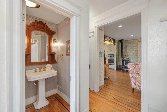 a view of a hallway with wooden floor and dining room