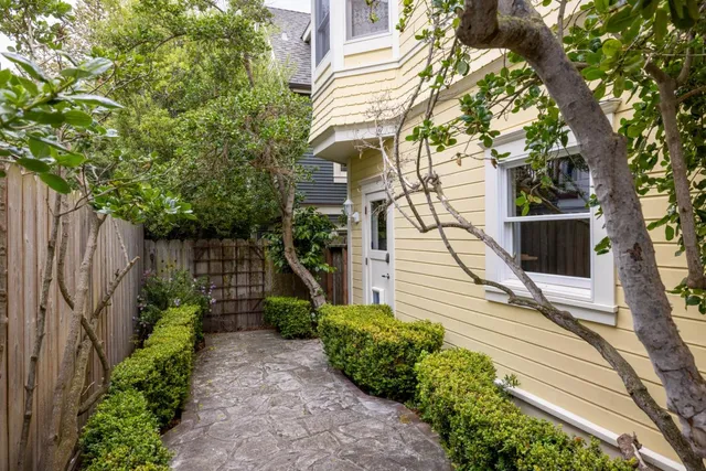 a view of a pathway of a house with a small yard