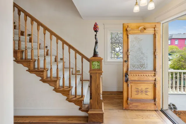 a view of staircase with wooden floor and a large window