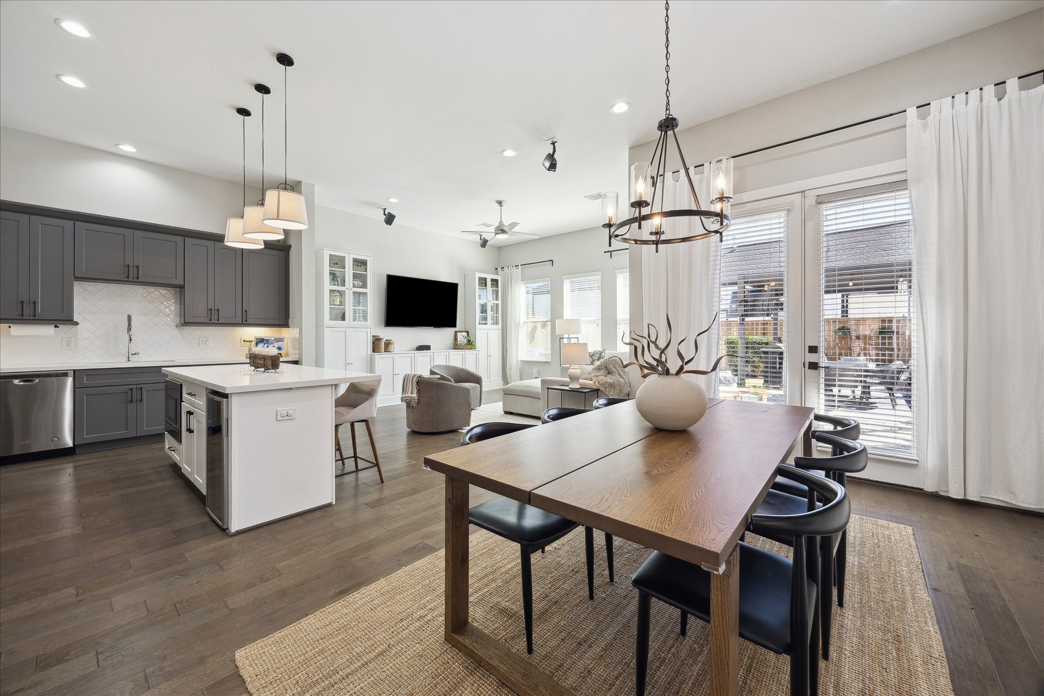 a open kitchen with stainless steel appliances granite countertop a stove a refrigerator a kitchen island a sink dishwasher a dining table and chairs with wooden floor