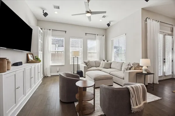 a living room with furniture a flat screen tv and a large window
