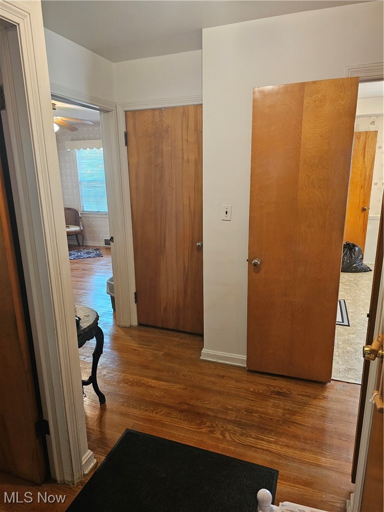 Hallway with hardwood / wood-style floors