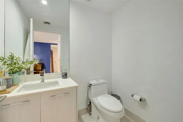 a bathroom with a sink vanity mirror and toilet