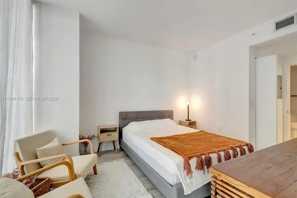 a bed sitting in a bedroom next to a window