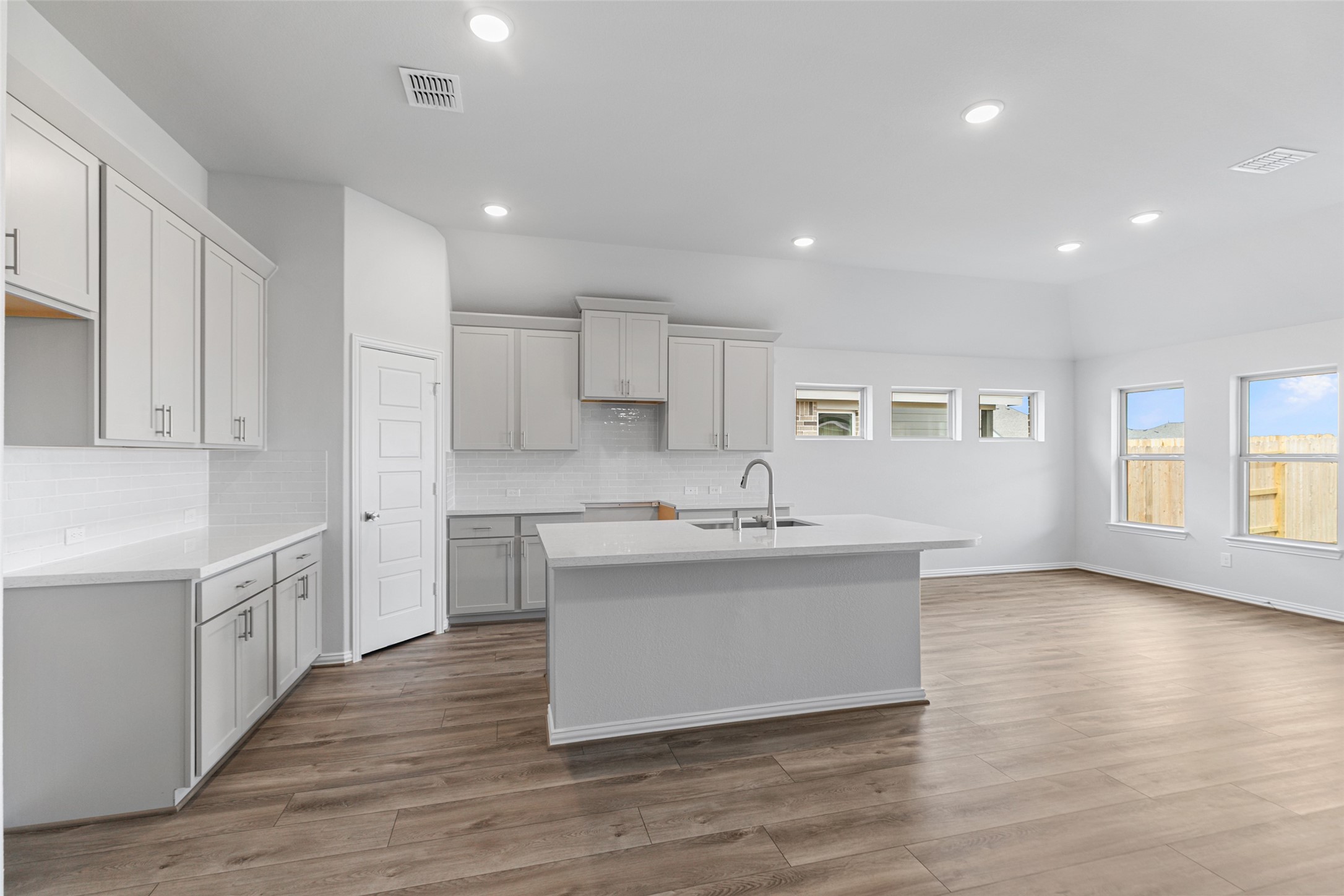 803 Evergreen Frst Lane Rosharon, TX 77583 - Photo 15 of 31 a large white kitchen with kitchen island a sink wooden floor and a refrigerator