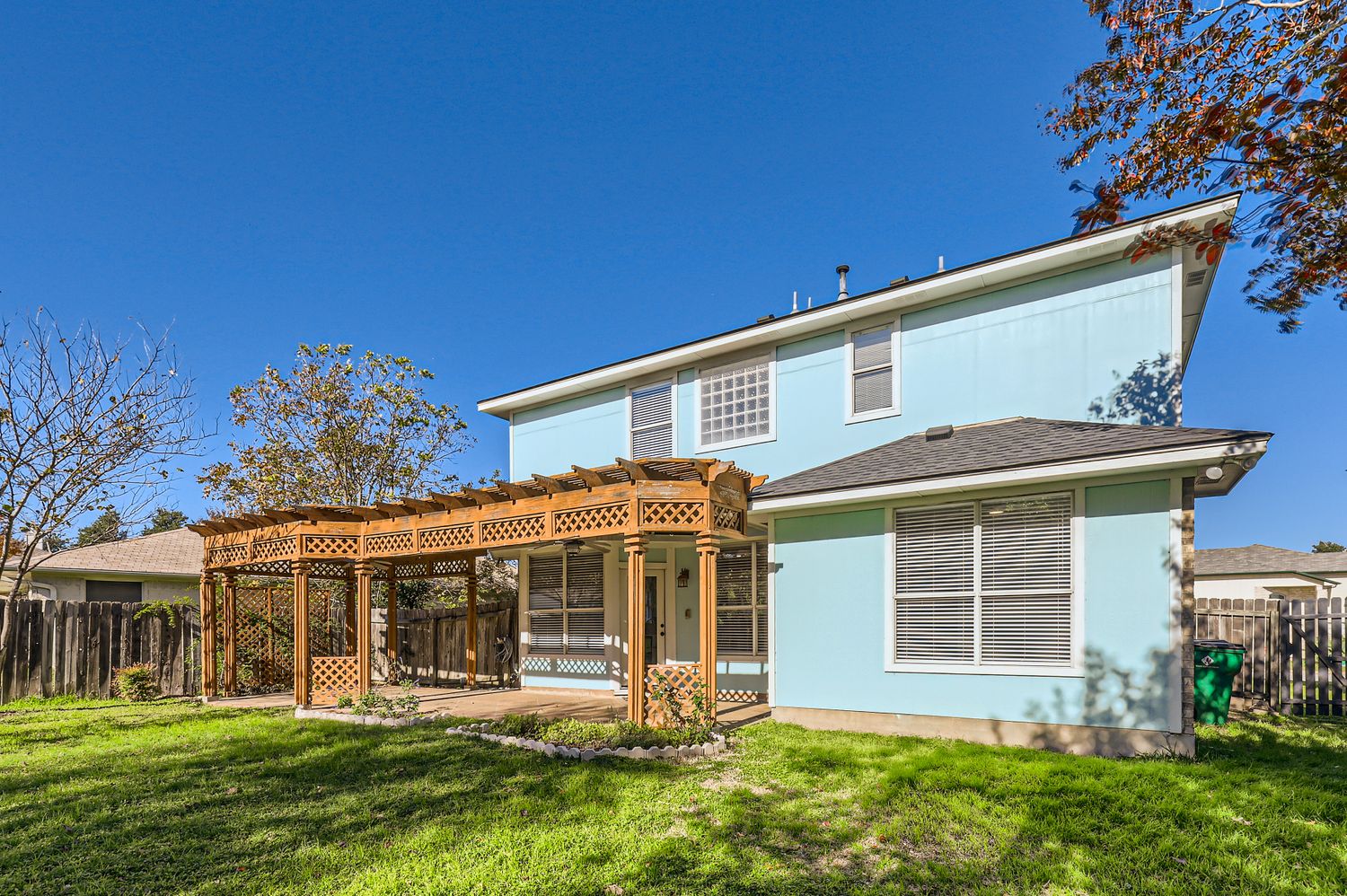 3805 Mankins Way Austin, TX 78728 - Photo 11 of 11 Back of house with a fenced backyard, a pergola, a patio, and stucco siding