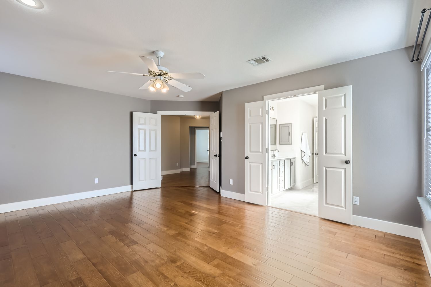 3805 Mankins Way Austin, TX 78728 - Photo 5 of 11 Unfurnished bedroom featuring light wood-style floors, a ceiling fan, and ensuite bath