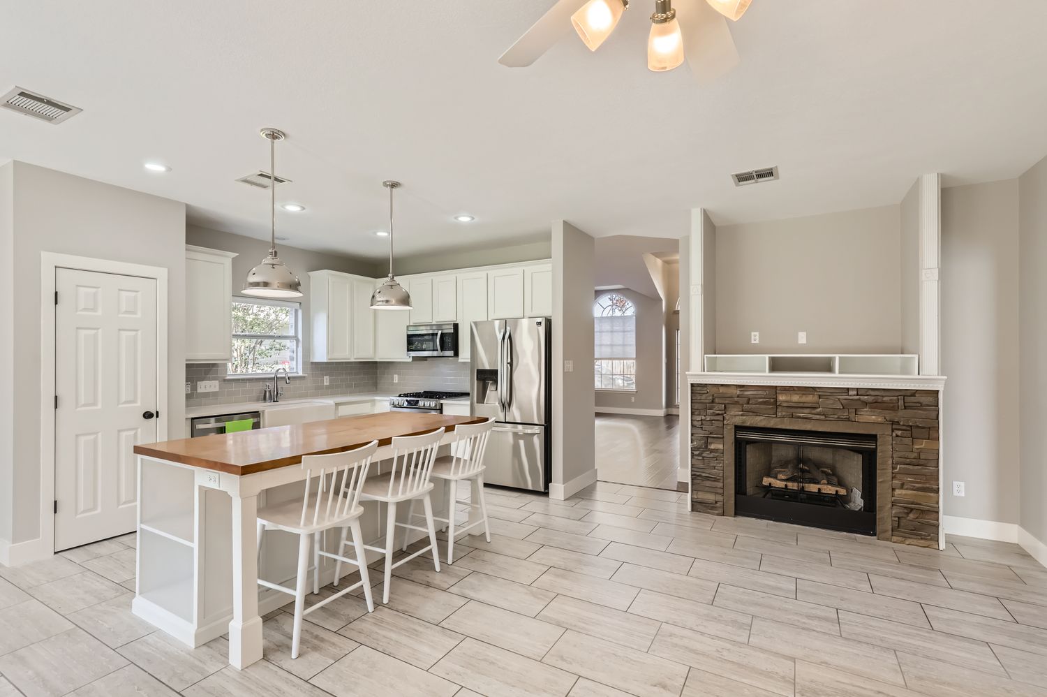 3805 Mankins Way Austin, TX 78728 - Photo 10 of 11 Kitchen with butcher block countertops, a kitchen bar, a kitchen island, stainless steel appliances, and a fireplace