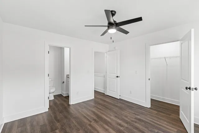 a view of a room with wooden floor and ceiling fan