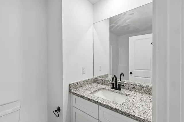a bathroom with a granite countertop sink and a mirror