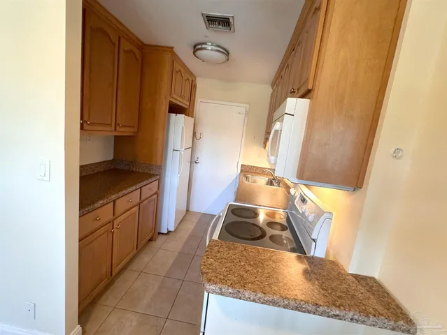 a kitchen with granite countertop a sink stove and cabinets