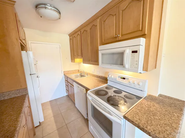 a kitchen with granite countertop a refrigerator and a stove