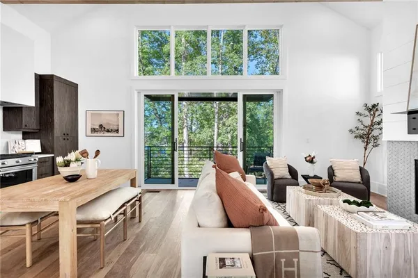 a open kitchen with stainless steel appliances granite countertop a stove a refrigerator a sink a dining table and chairs with wooden floor