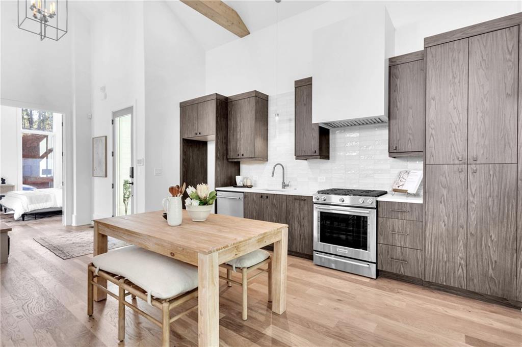 1250 Lupo Loop Chattahoochee Hills, GA 30268 - Photo 13 of 49 a kitchen with stainless steel appliances granite countertop a stove a sink dishwasher and a refrigerator with wooden floor