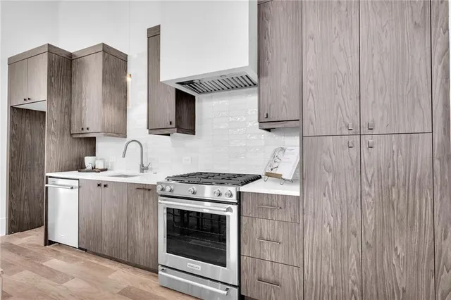 a kitchen with stainless steel appliances a sink a stove and cabinets
