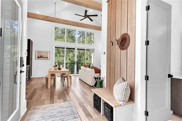 a living room with stainless steel appliances furniture a large window and wooden floor
