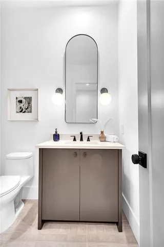 a bedroom with a bed and a lamp on dresser