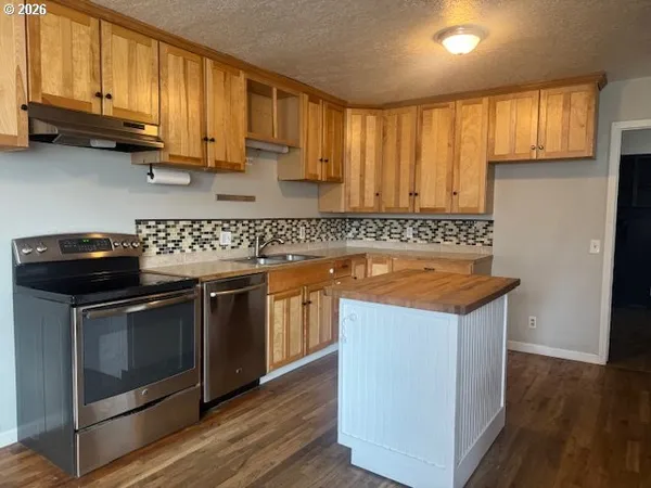 a kitchen that has a sink and a stove in it