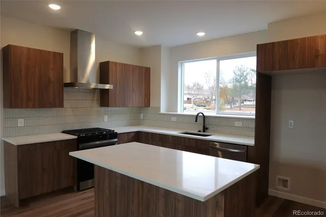 a kitchen with stainless steel appliances granite countertop a sink window and a refrigerator