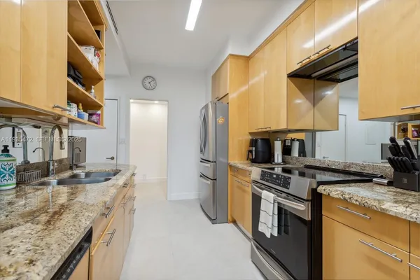 a kitchen with stainless steel appliances granite countertop a sink a stove and a refrigerator