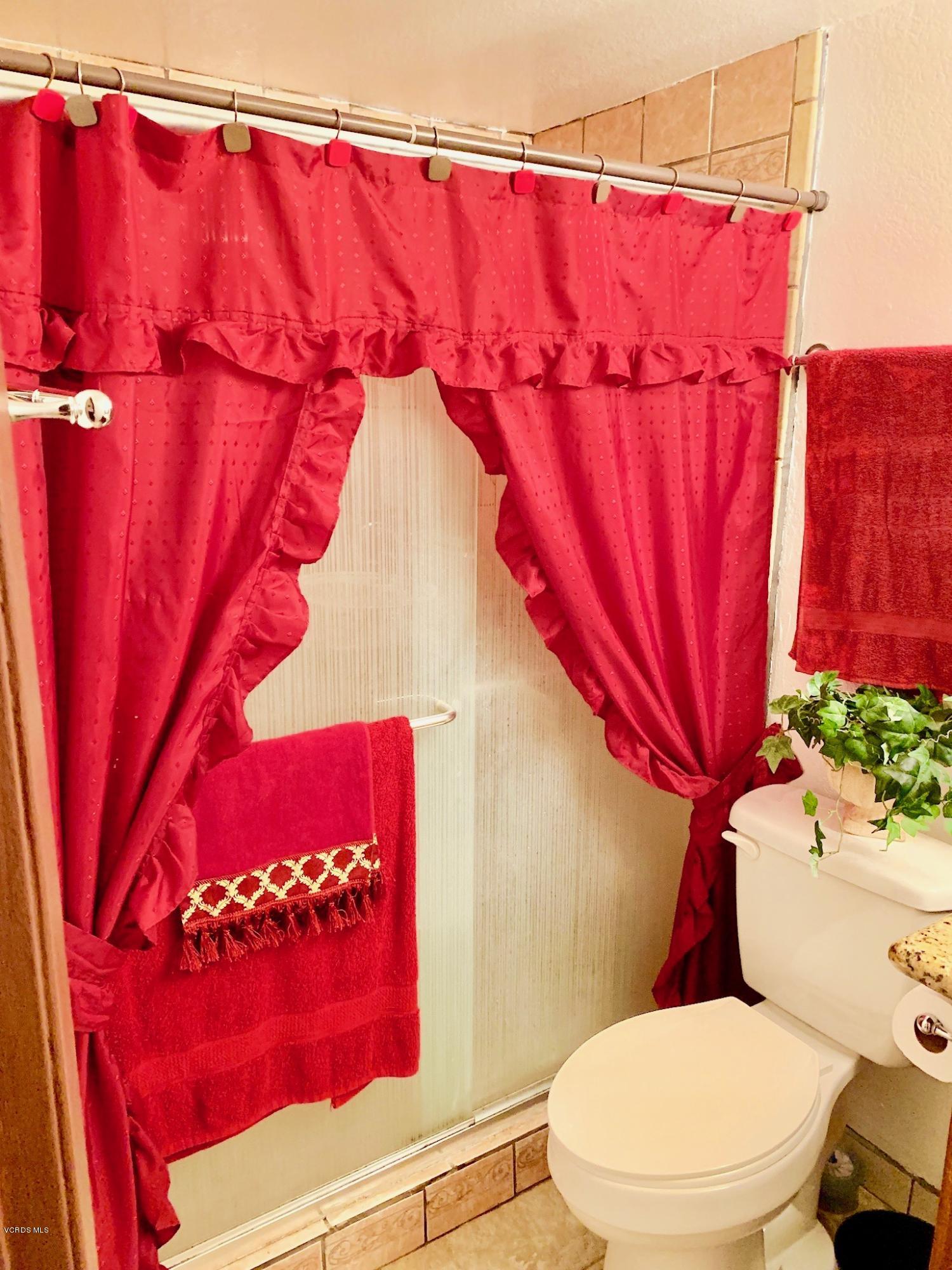 4562 Saviers Road Oxnard, CA 93033 - Photo 16 of 29 a bathroom with a toilet and a shower curtain