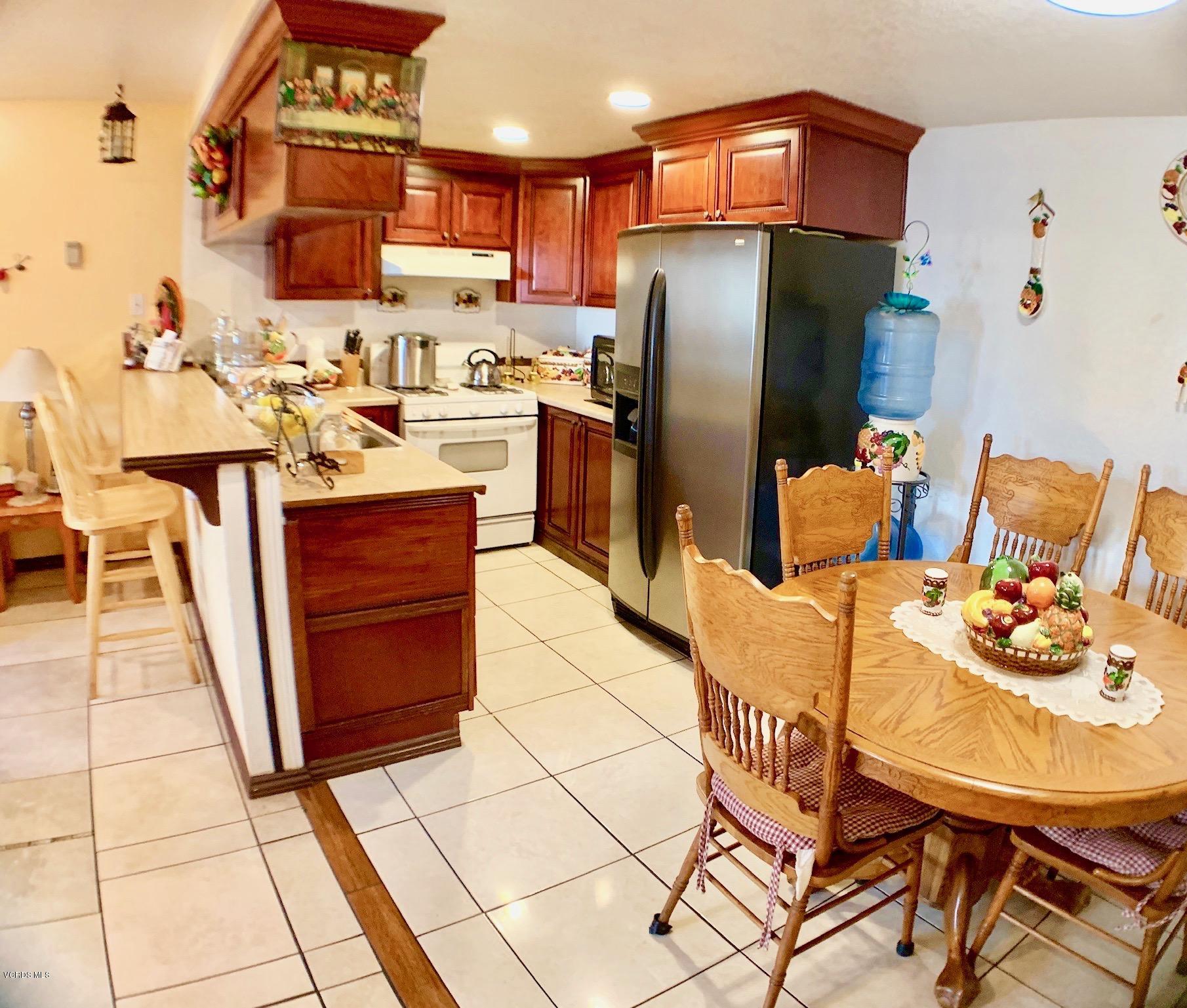 4562 Saviers Road Oxnard, CA 93033 - Photo 10 of 29 a kitchen with stainless steel appliances kitchen island granite countertop a table chairs and a refrigerator