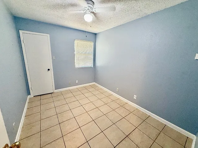 a view of a room with a chandelier fan and windows