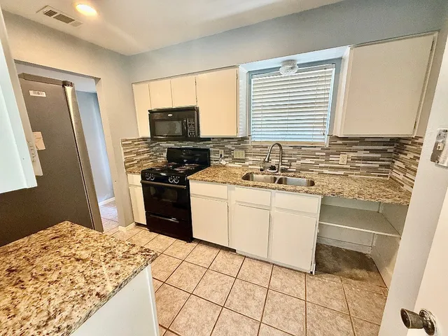 a kitchen with a stove a sink and a refrigerator
