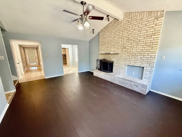 an empty room with windows and fireplace