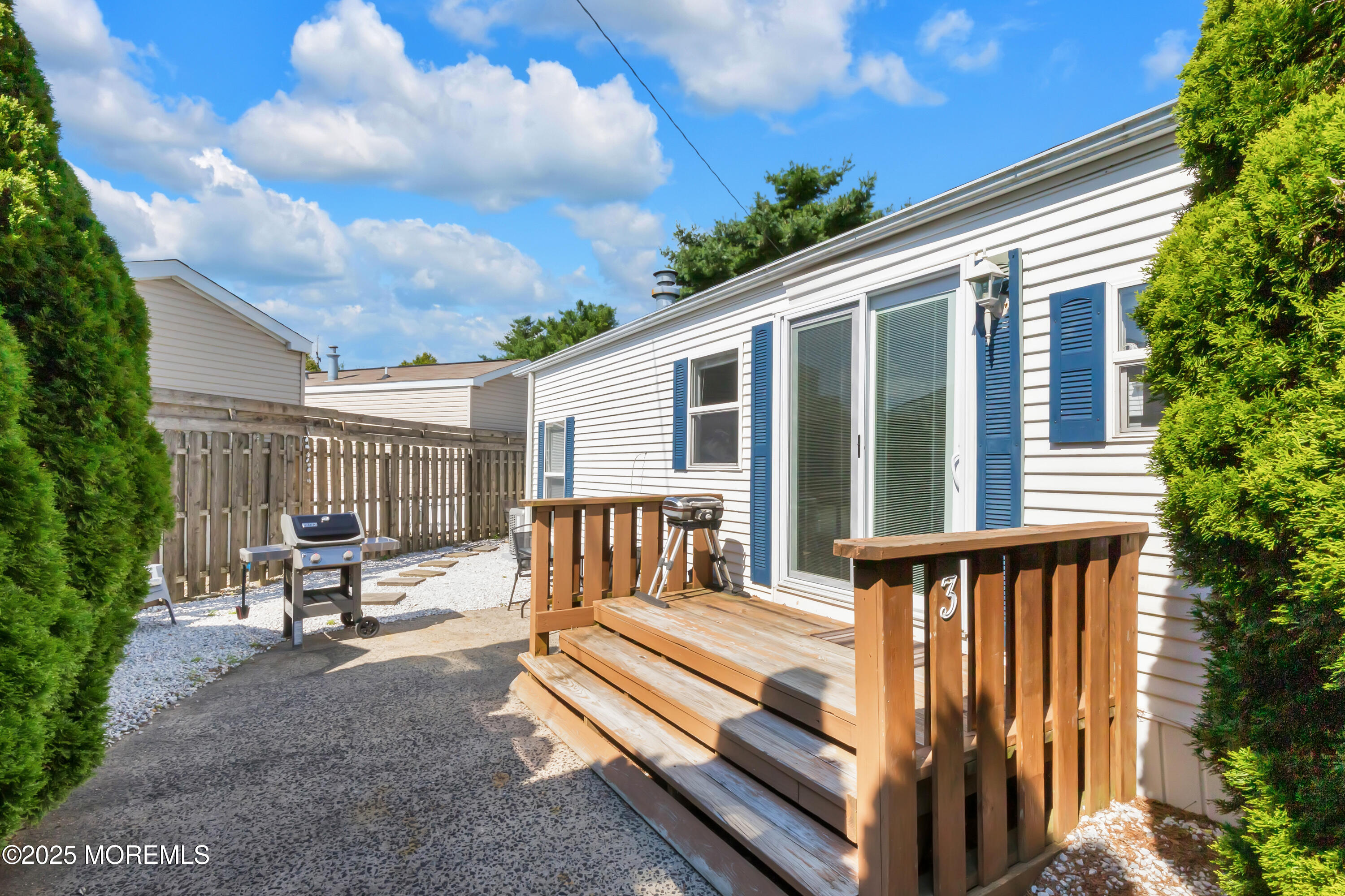 709 Union Avenue, Unit 3 Brielle, NJ 08730 - Photo 3 of 17 a view of a patio with table and chairs with wooden floor and fence