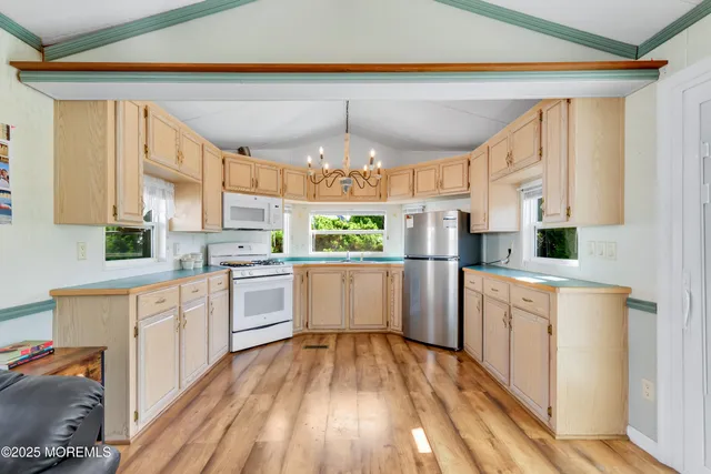 a kitchen with white cabinets and white appliances