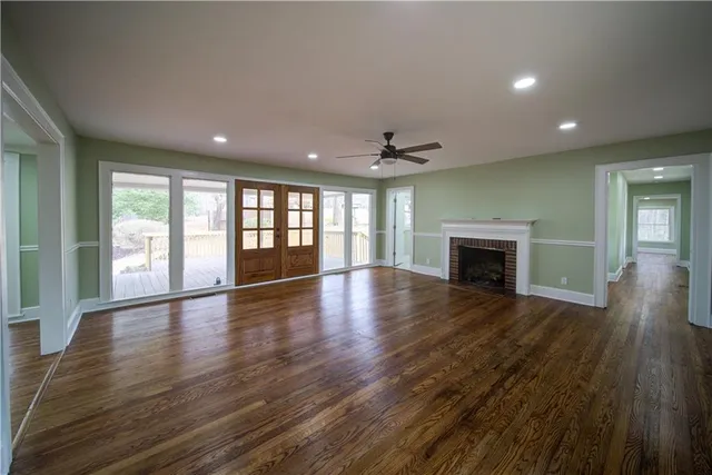an empty room with wooden floor and fireplace