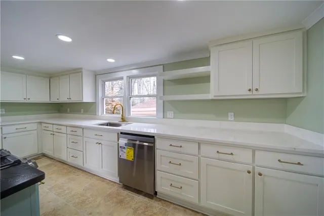 a kitchen with granite countertop white cabinets and white appliances