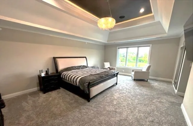 a spacious bedroom with a bed and a chandelier