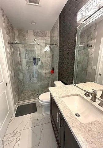 a bathroom with a sink a toilet and shower