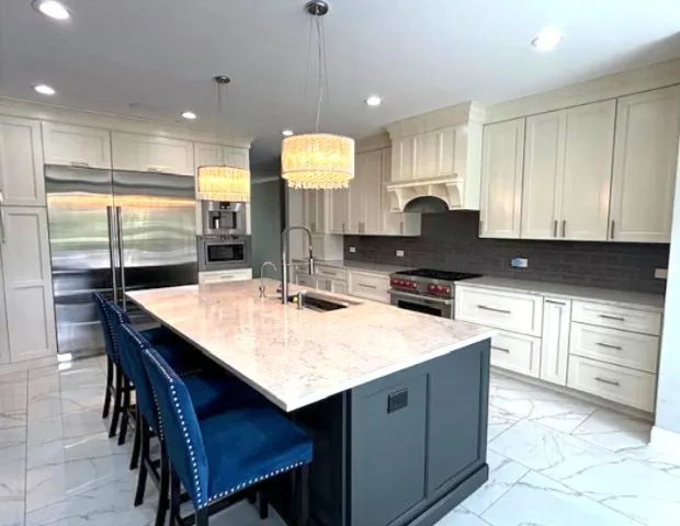 a kitchen with kitchen island granite countertop a sink a stove a dining table and chairs