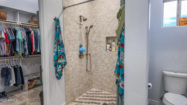 a view of walk in closet with clothes and shoes