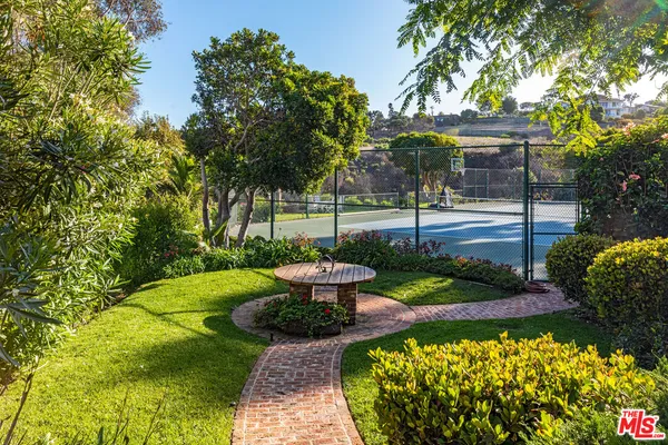 a view of a fountain with flower in a garden