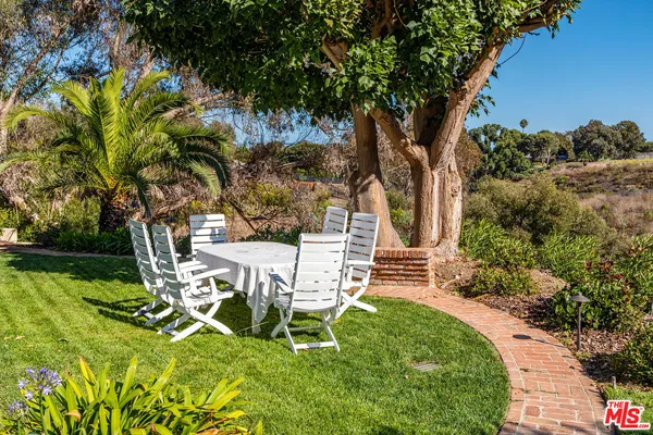 a view of a chairs and table in the garden