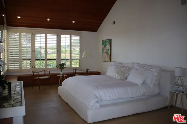 a bed room with a bed and a large window