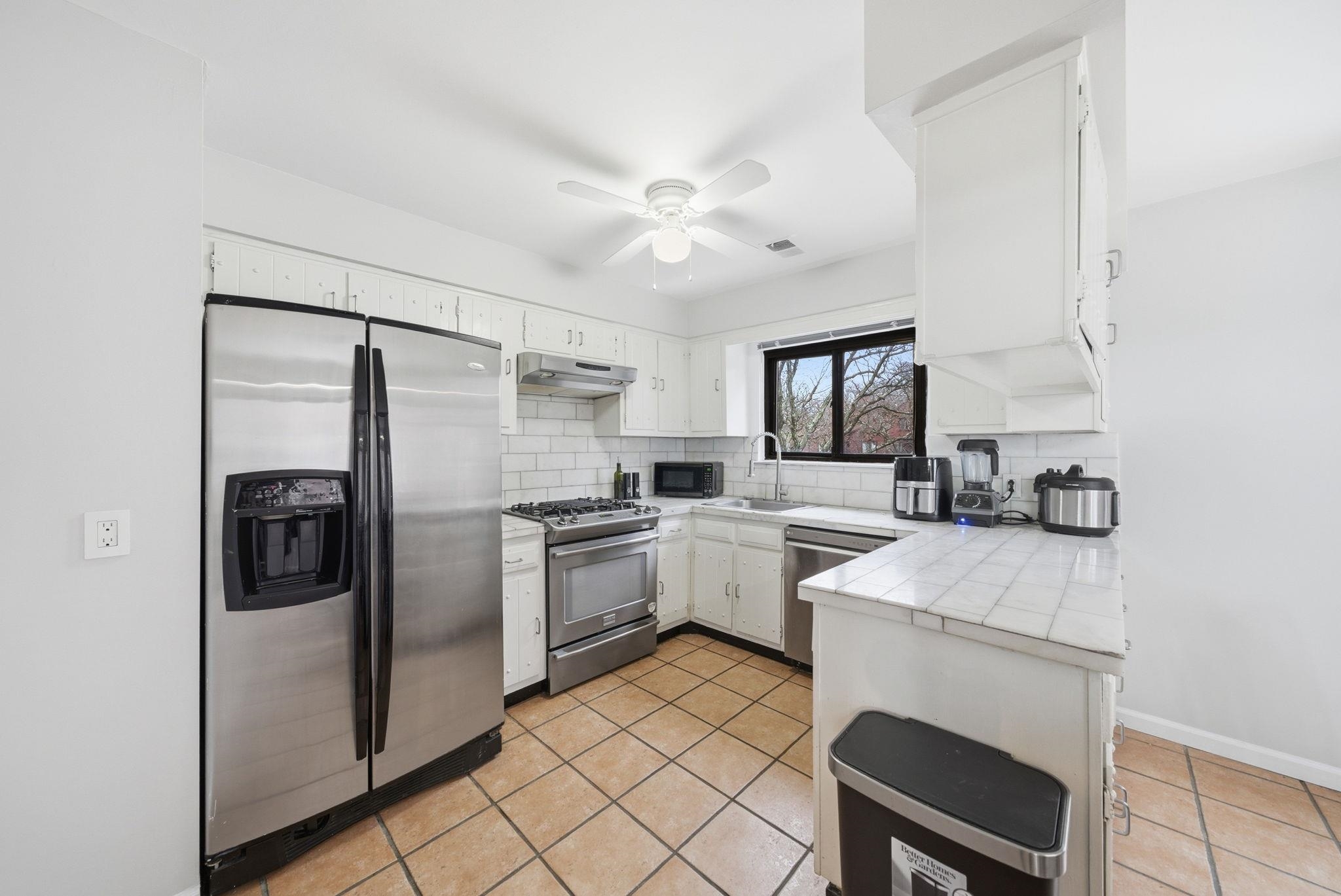 274 Sunset Key, Unit 274 Secaucus, NJ 07094 - Photo 14 of 50 a kitchen with white cabinets and stainless steel appliances