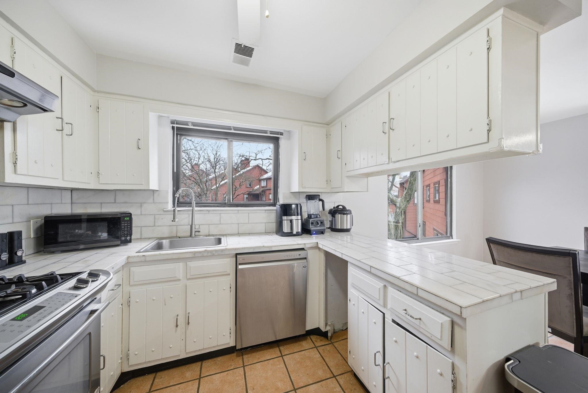 274 Sunset Key, Unit 274 Secaucus, NJ 07094 - Photo 16 of 50 a kitchen with white cabinets and white appliances