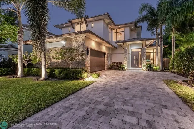 a view of a white house with a yard and plants