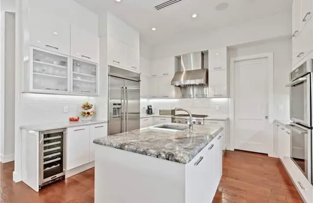 a kitchen with white cabinets and appliances
