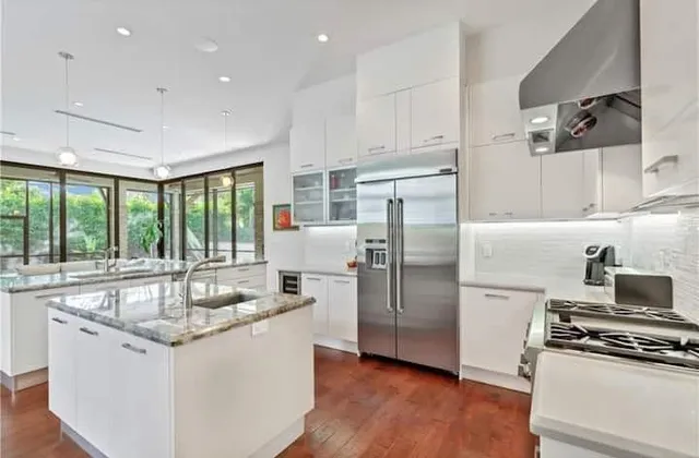 a kitchen with stainless steel appliances granite countertop a sink stove and refrigerator