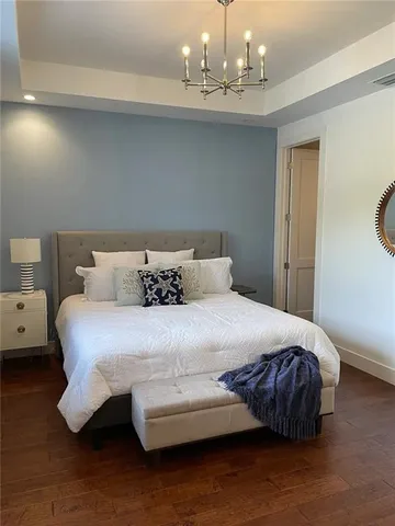 a bedroom with a bed and a chandelier